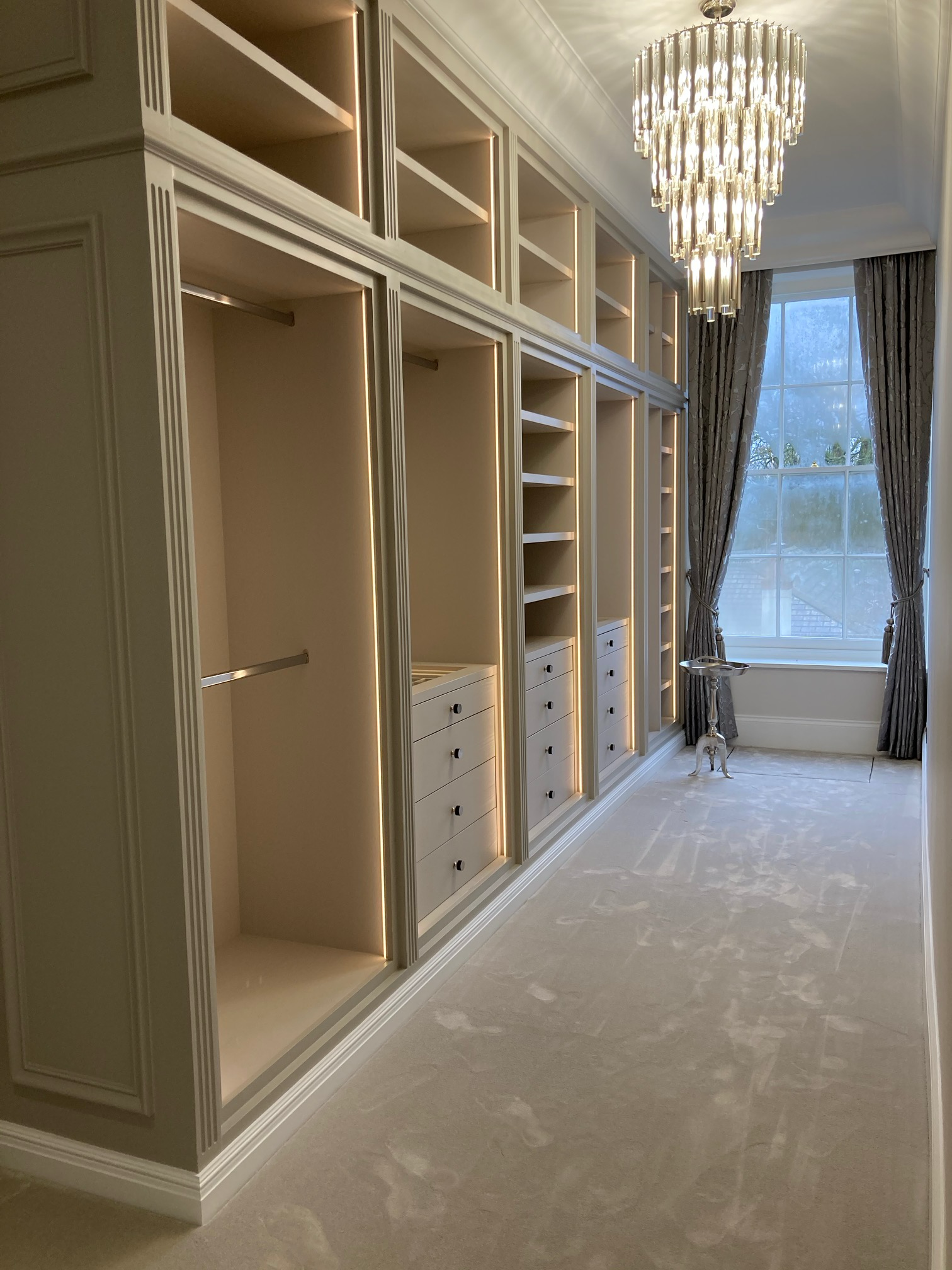 Bespoke fitted dressing room at Whaddon Hall — hand-built joinery and warm sage cabinetry