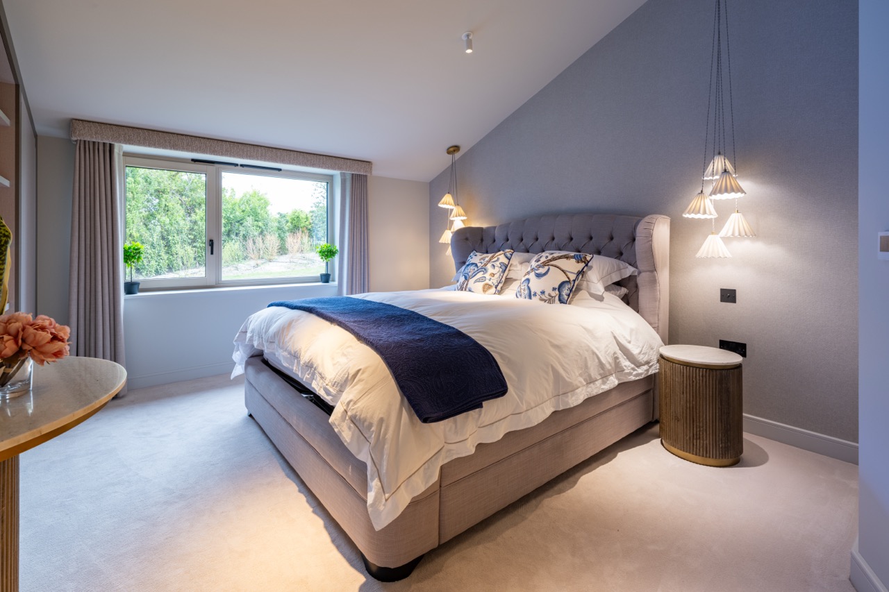 Queens Orchard guest bedroom with buttoned headboard and blue accents