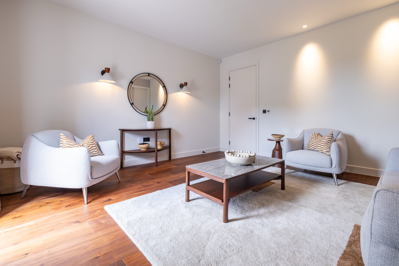 Queens Orchard sitting room with walnut flooring and pale armchairs