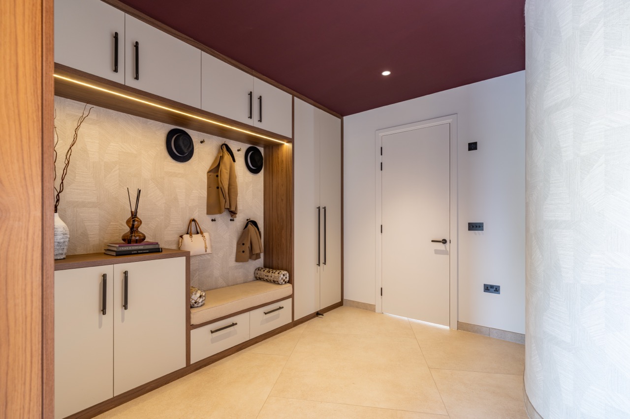 Queens Orchard boot room with fitted storage, bench seat and a deep burgundy painted ceiling